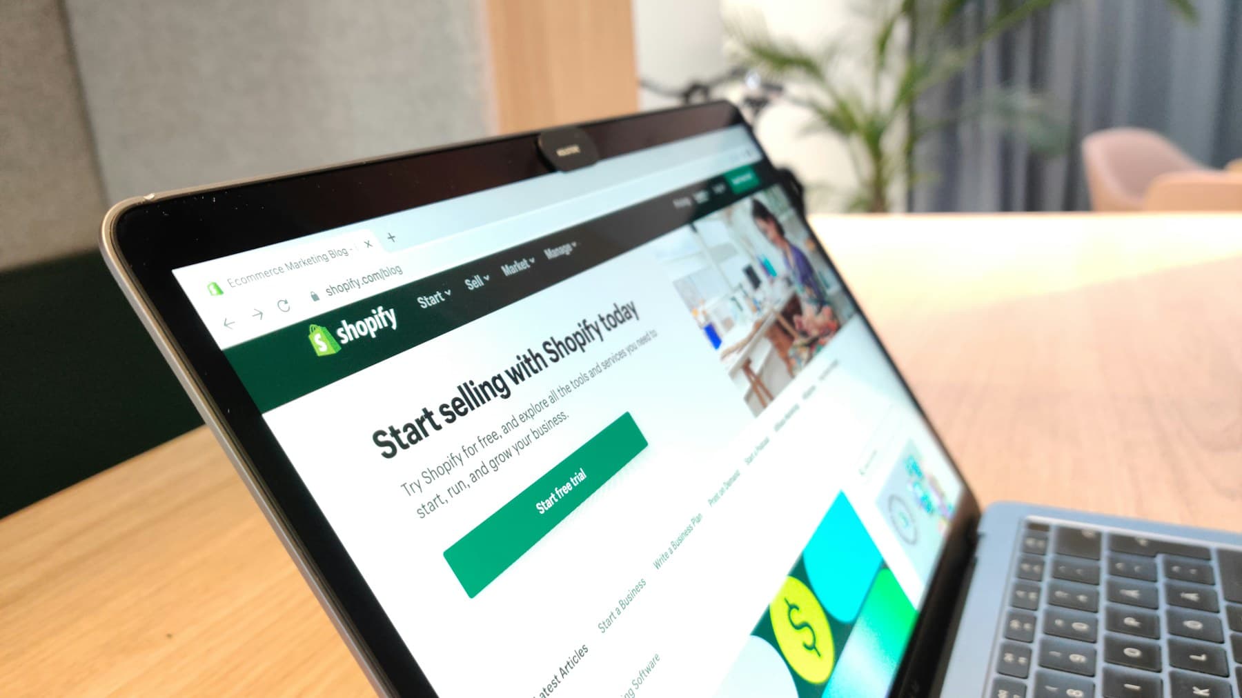 Laptop showing an online store homepage on a wooden desk