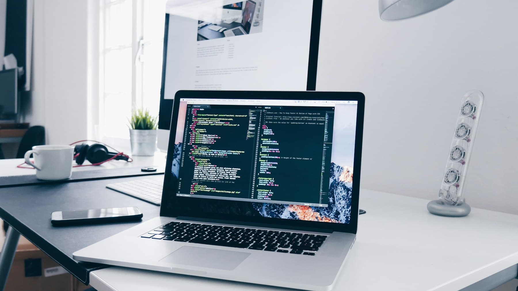Laptop showing website code on a developer's desk